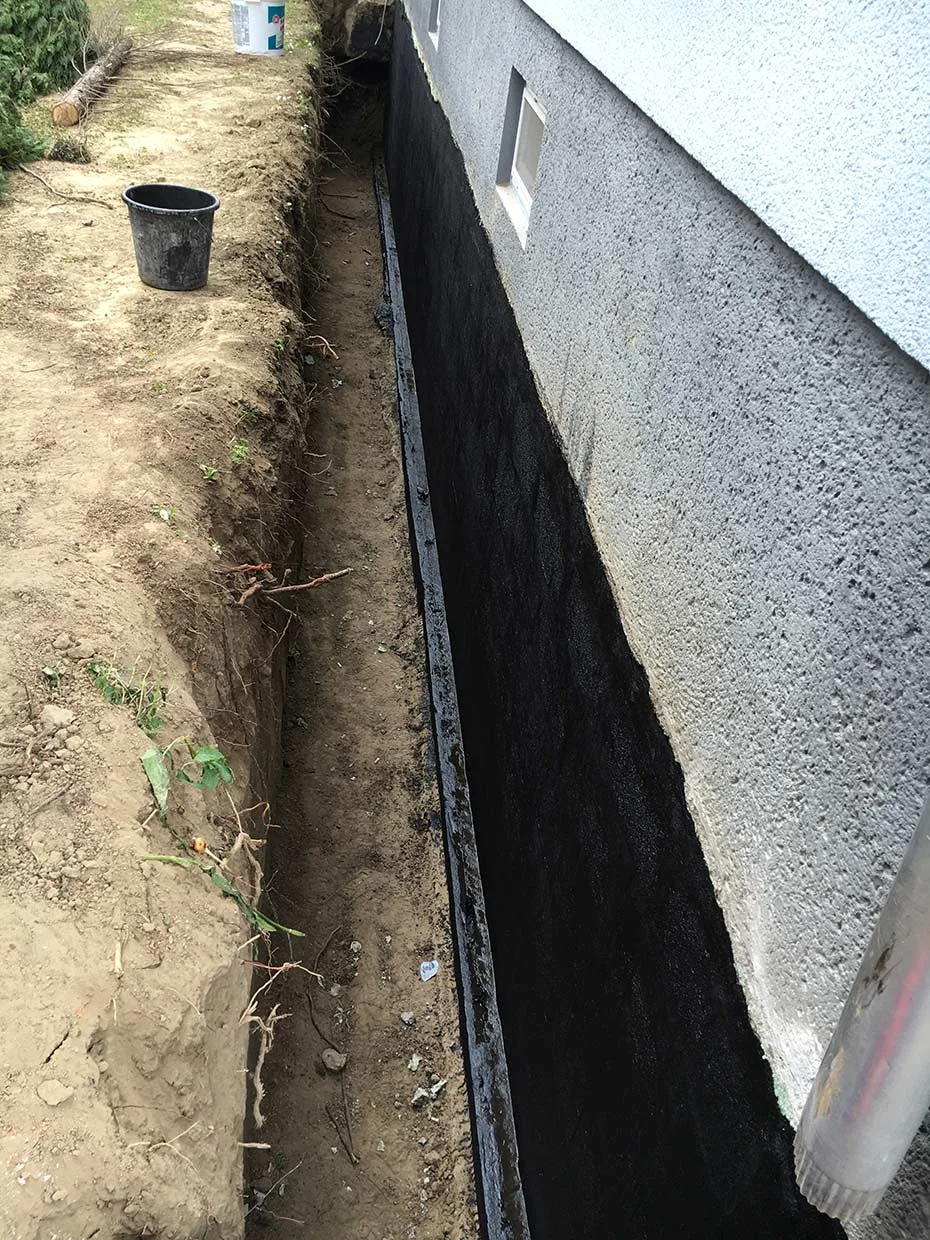 Freigelegte Kellerwand bei Isolierungsarbeiten